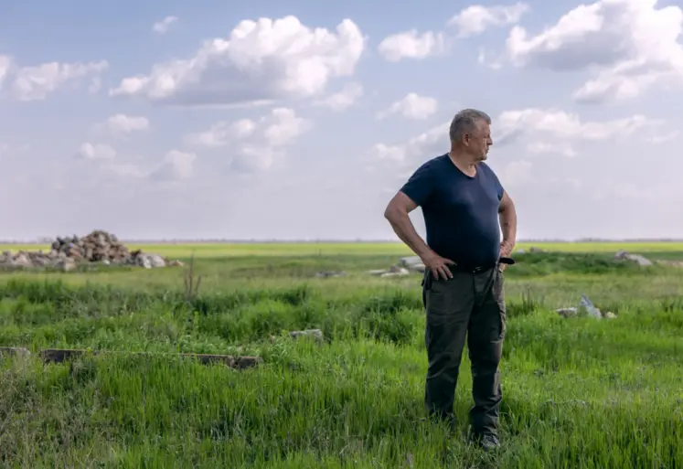 agriculteur dans son champ avec débris au sol