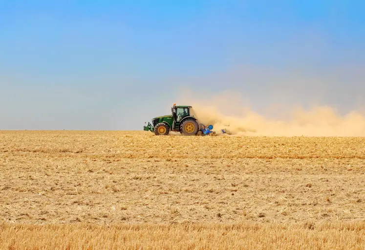 Tracteur dans un champ très sec après la moisson