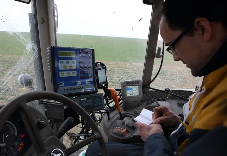 Agriculteur dans son tracteur notant dans son carnet les traitements phyto réalisés.
