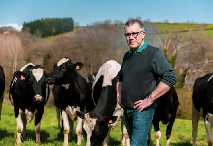 Un homme posant devant ses vaches en extérieur