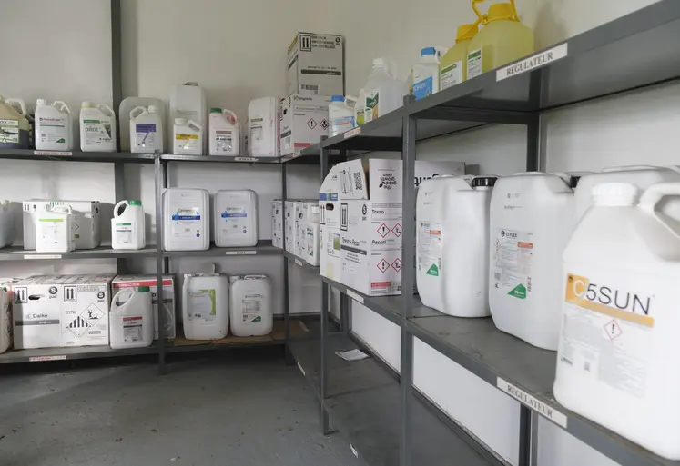 Local phytosanitaire dans une exploitation agricole, avec des bidons et 