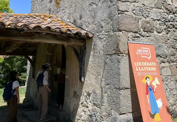 Panneau des "débats à la ferme" de l'association Les Voix Agricoles lors de la journée chez Nicolas Clair dans la Loire, avec derrière l'entrée de la chapelle Saint-Sulpice. 