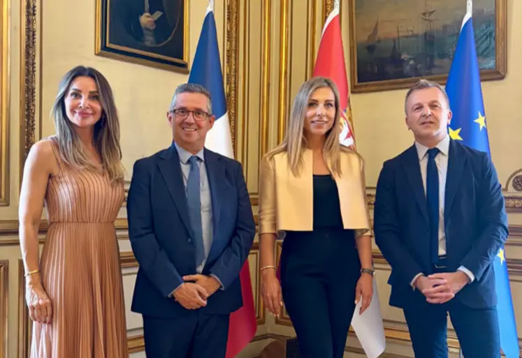 Deux hommes et deux femmes posent pour la photo avec des derapeaux en arrière-plan