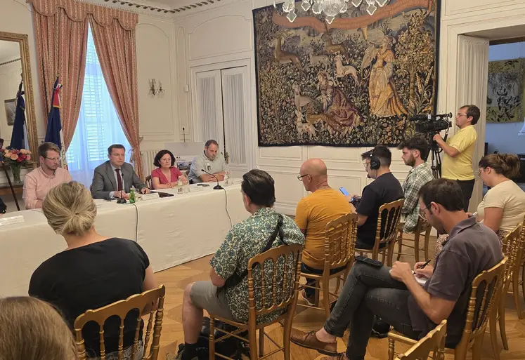u  groupe de personnes assis derrière une table répondant à des journalistes