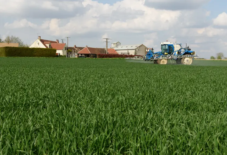  Pulvérisateur dans un champ près d’habitations