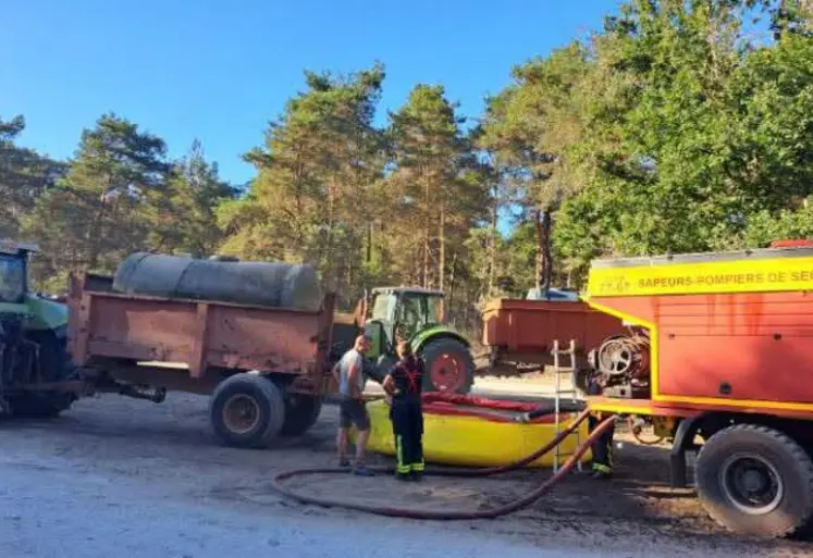Agriculteur aidant à ravitailler les pompiers en eau dans la forêt de Fontainebleau avec sa tonne à eau.