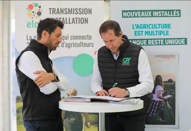 Deux hommes signant un accord sur la transmission et l'installation en agriculture.