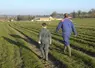 Un homme et un enfant en tenue d'agriculteur marchent dans un champ