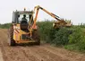 Machine entretenant une haie en bordure de parcelle agricole