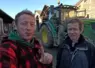 Etienne Fourmont et Jean-Marc Jancovici devant un tracteur dans une cour de ferme.