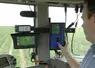 Agriculteur au volant de son tracteur devant le tableau de commande du pulvérisateur. 