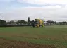 tracteur épandant des pesticides dans un champ