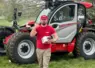 un homme posant devant une engin manitou