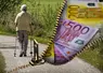  Femme âgée marchant dans la campagne avec des billets en euros à côté. 
