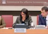 trois personnes assises devant un micro