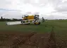 tracteur épandant des pesticides dans un champ