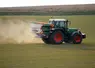 Un tracteur épand un engrais azoté (ammonitrate) sur un champ de céréales. 