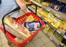 personne tenant un panier de courses dans un supermarché