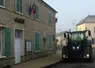 tracteur passant devant une mairie dans un village
