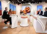 Plateau de télévision avec cinq personnes assises derrière un pupitre