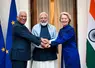Le président du Conseil européen António Costa, le Premier ministre de l’Inde Narendra Modi et la présidente de la Commission européenne Ursula von der Leyen mains dans les mains à New Delhi devant des drapeaux de l'Union européenne et de l'Inde.   
