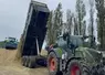 Tracteur déversant du maïs ensilage dans un silo   