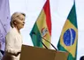 Ursula von der Leyen présidente de la Commission européenne devant les drapeaux du Mercosur et du Brésil