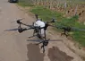 drone posé sur la route en bordure de champ