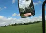 Champ de blé depuis la cabine d'un tracteur avec le rétroviseur visible. 