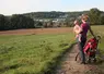   Femme avec son bébé dans les bras en promenade dans les champs  