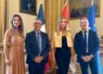 Deux hommes et deux femmes posent pour la photo avec des derapeaux en arrière-plan