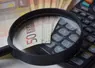 billets de 50 euros avec une loupe et une calculatrice
