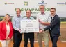 un  groupe de personnes tient un document pour la photo