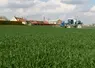  Pulvérisateur dans un champ près d’habitations