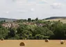 paysage rural avec champ et bottes de paille au premier plan et village en arrière plan