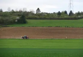 Paysage agricole de grandes cultures en Bourgogne (Côte d' Or) au printemps avec tracteur, zone intermédiaire.