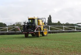 tracteur épandant des pesticides dans un champ