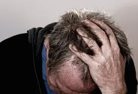 homme en détresse se tenant la tête dans les mains 