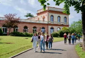 des élèves marchent sur une allée avec un bâtiment en briques en arrière-plan