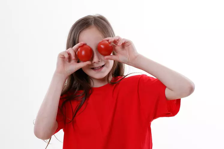 enfant avec deux tomates 
