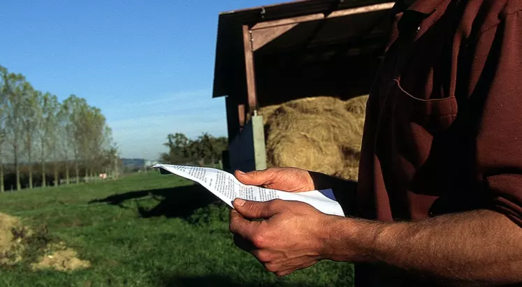 Agriculteur lisant un document.