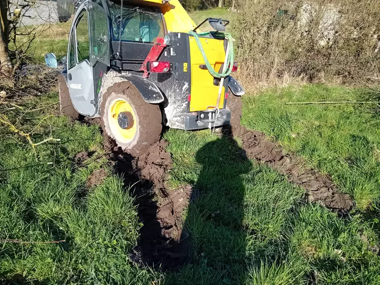 Tracteur embourbé dans un champs  lors d'une opération de taille de haie