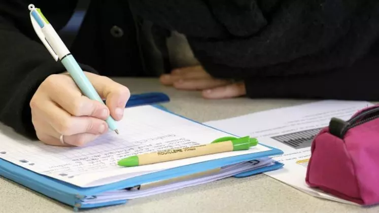 Elève écrivant sur un cahier.