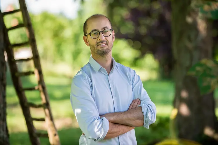   Benoît Grimonprez, professeur à l’université de Poitiers, dans un verger devant une échelle.