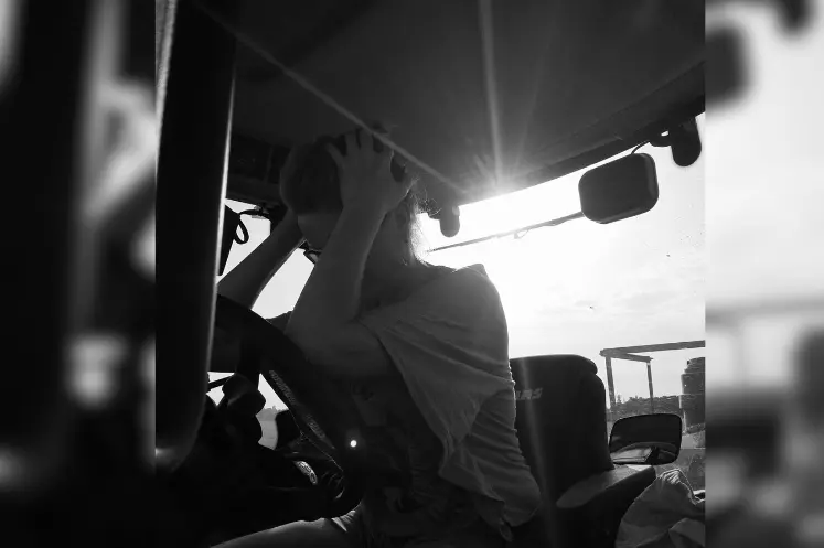 Une agricultrice dans un tracteur la tête dans les mains