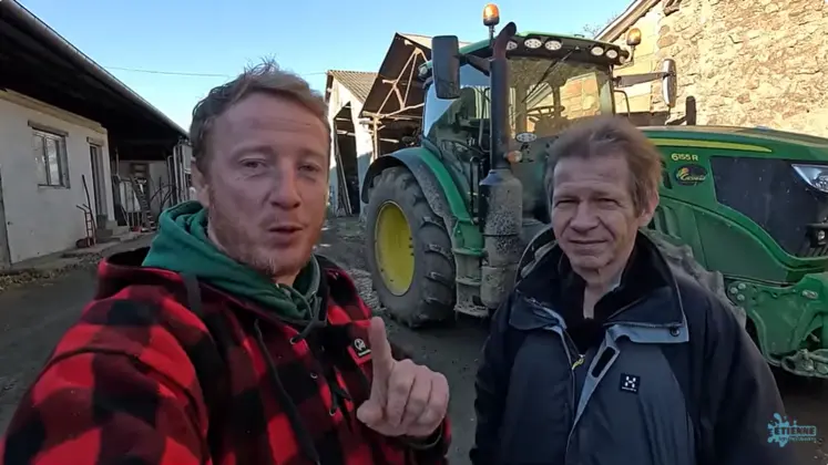 Etienne Fourmont et Jean-Marc Jancovici devant un tracteur dans une cour de ferme.