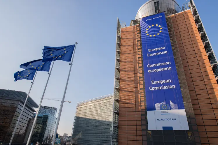 Bâitment du siège de la Commission européenne à Bruxelles, avec des drapeaux européens. 