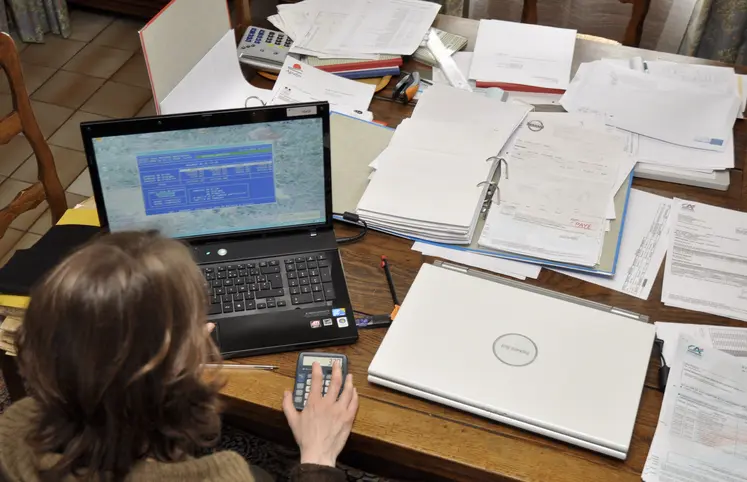 Agricultrice devant un ordinateur avec une calculatrice