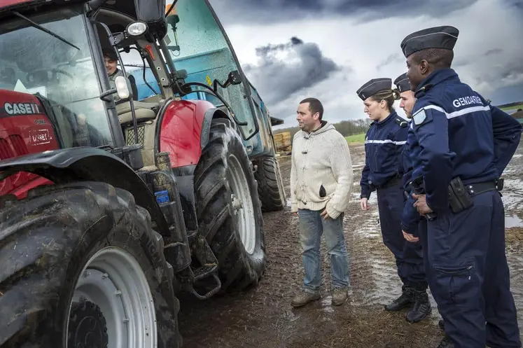 Gendarmes discutant avec un agriculteur devant un tracteur