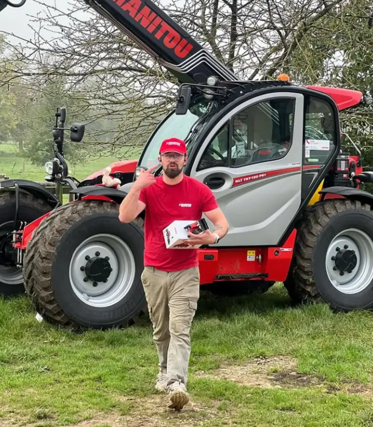 un homme posant devant une engin manitou